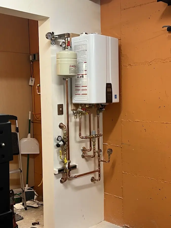 Plumbing technician inspecting water heater connections in West Ocean City